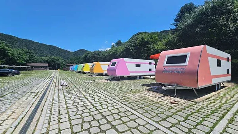 알록달록한 캐라반 객실이 전용 포장 주차면과 함께 나란히 배치된 모습