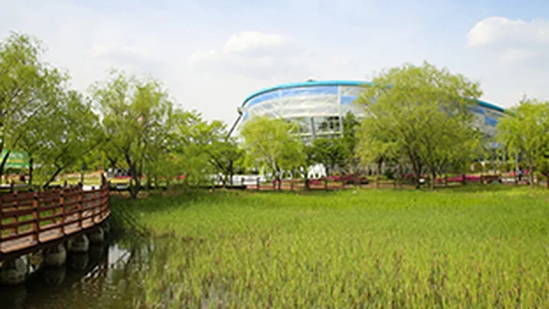가족 나들이객이 돗자리를 펴고 휴식을 즐기는 넓은 잔디마당