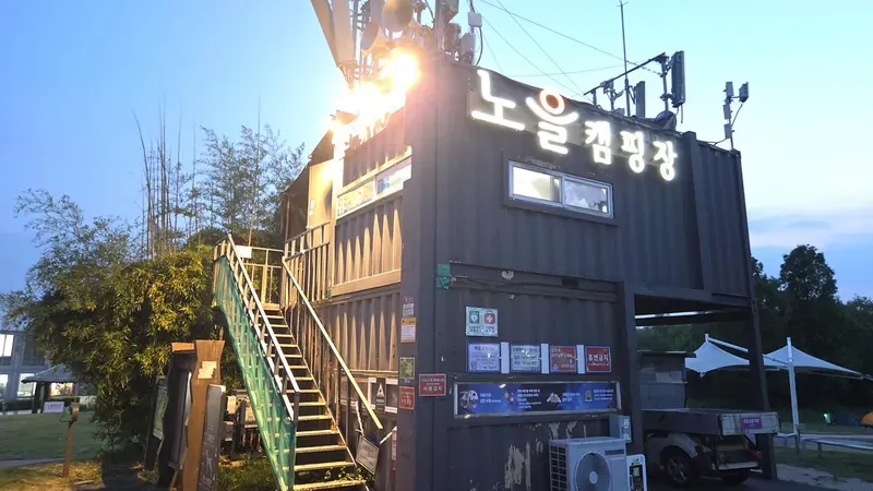 노을주차장에서 맹꽁이 전기차를 타고 정상에 도착하는 노을캠핑장 관리사무소 및 안내 데스크